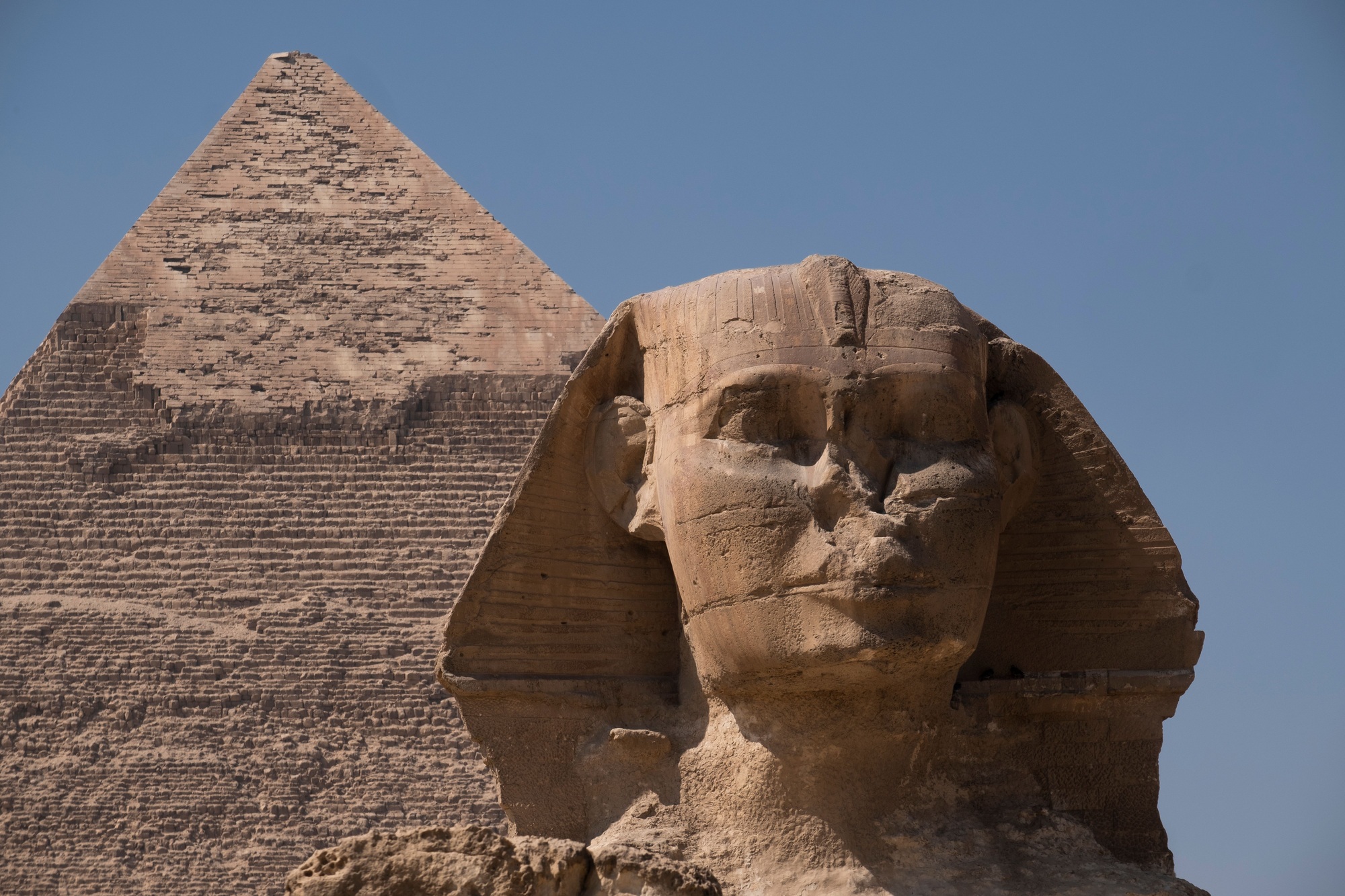 Front view of the Great Sphinx Giza and the Great Pyramid in Egypt under blue sky